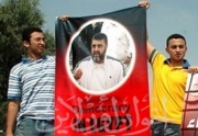 ابناء عصام عبد المحسن يرفعون صورة الشاطر امام المحكمة العسكرية.jpg